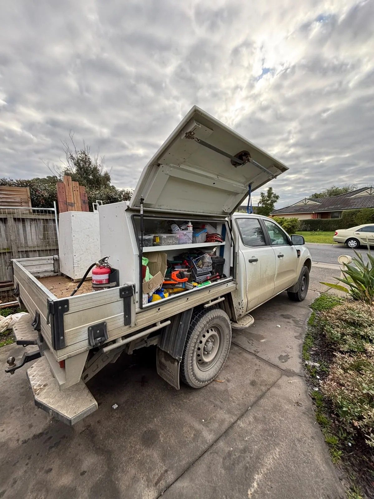 Grimy white Ford Ranger tradie ute with an open toolbox before detailing