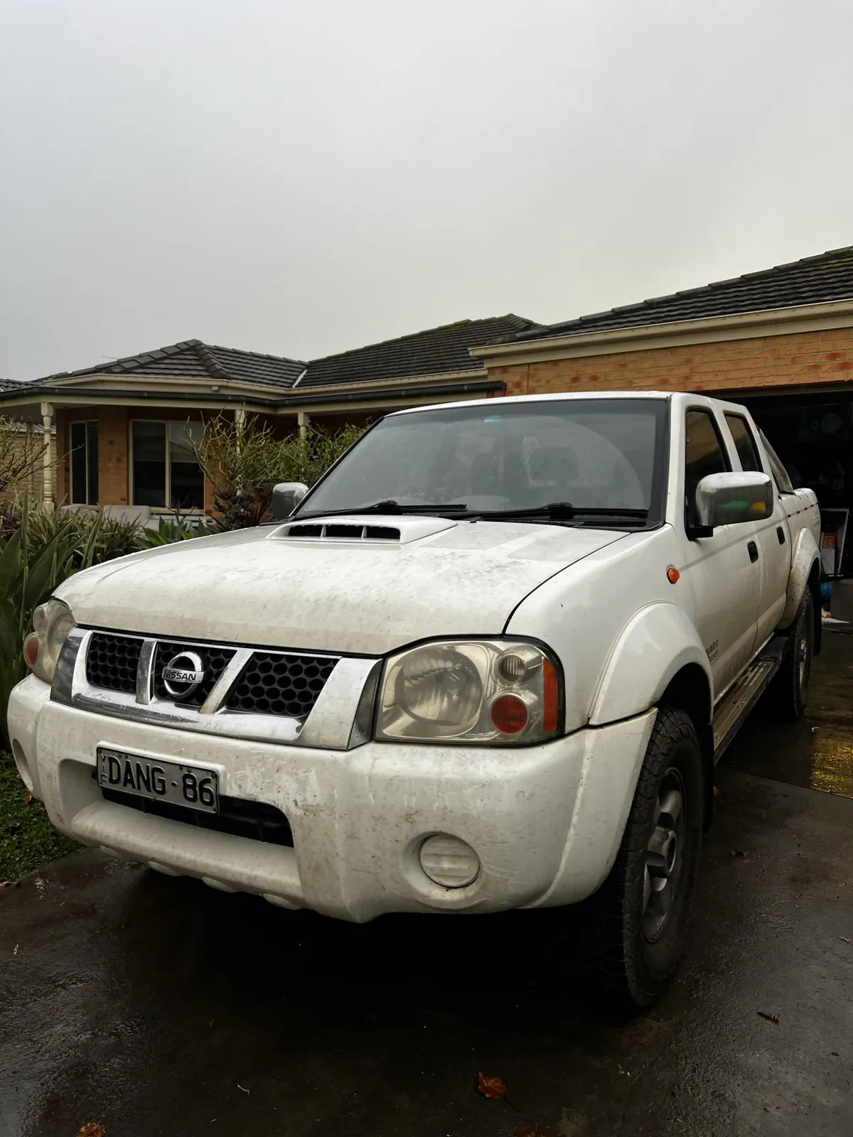 Mud-covered white Nissan ute before a tradie detail