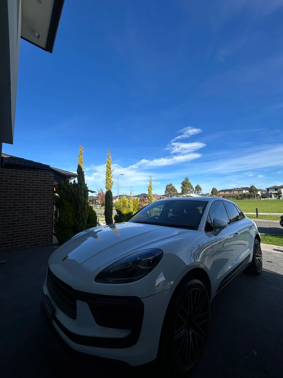 White Porsche Macan detailed to a mirror finish on a suburban driveway