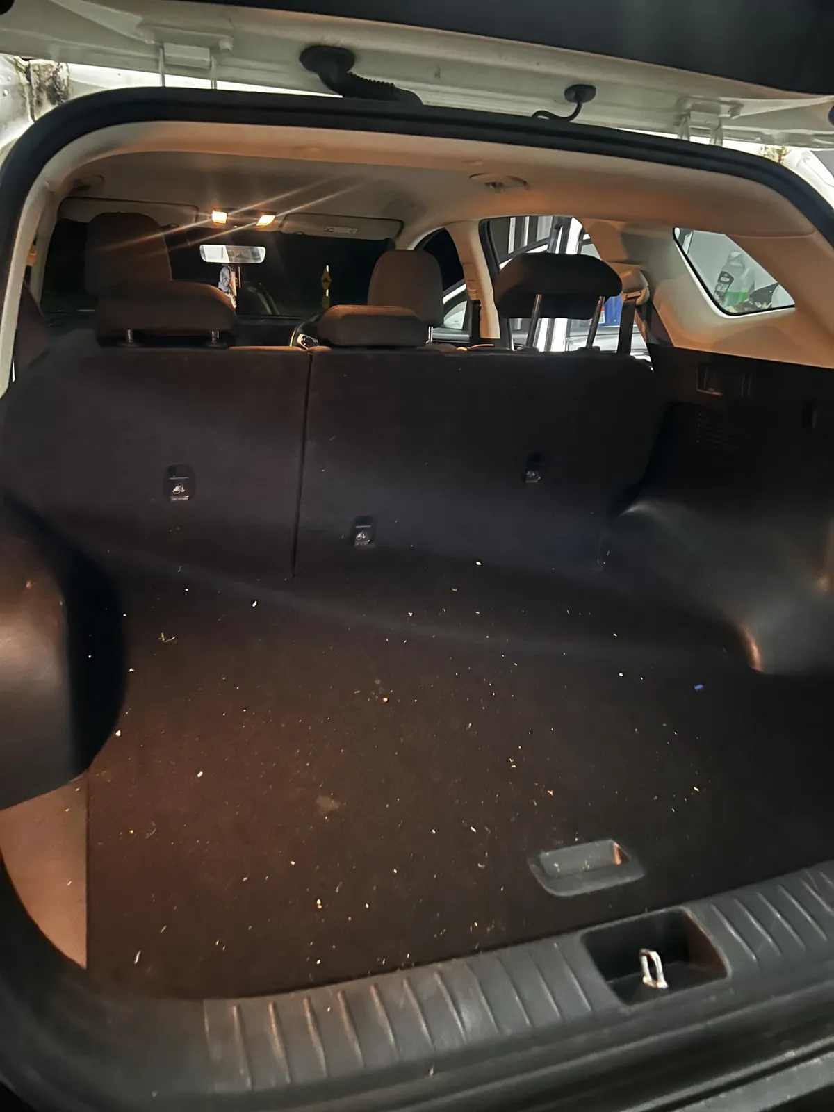SUV cargo area covered in dirt and debris before detailing